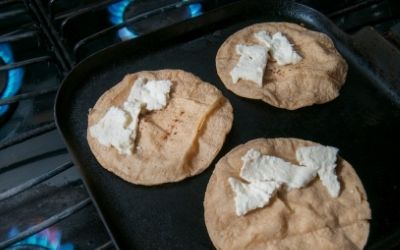 Corn tortillas for enchiladas on a griddle - Family Guide Central