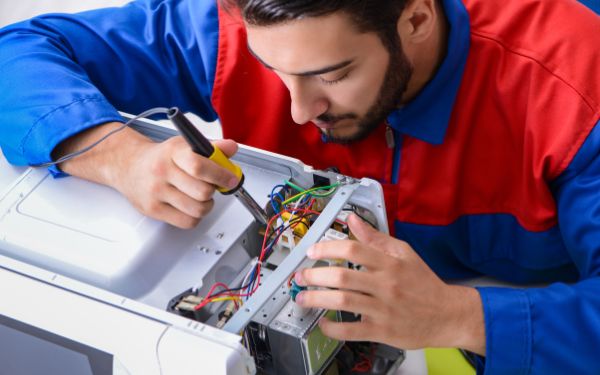 Man fixing Ninja Foodi air fryer - FamilyGuideCentral.com