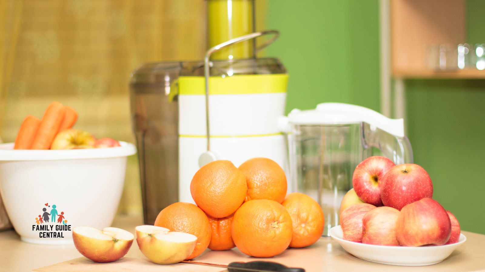 Centrifugal juicer with oranges apples carrots in front - familyguidecentral.com