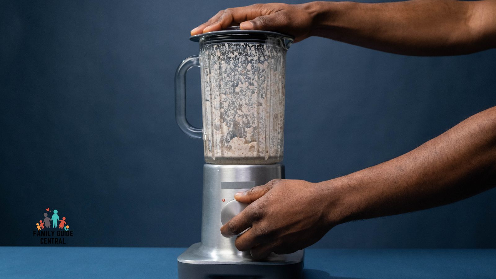 Dirty blender with hands holding top and dial - familyguidecentral.com